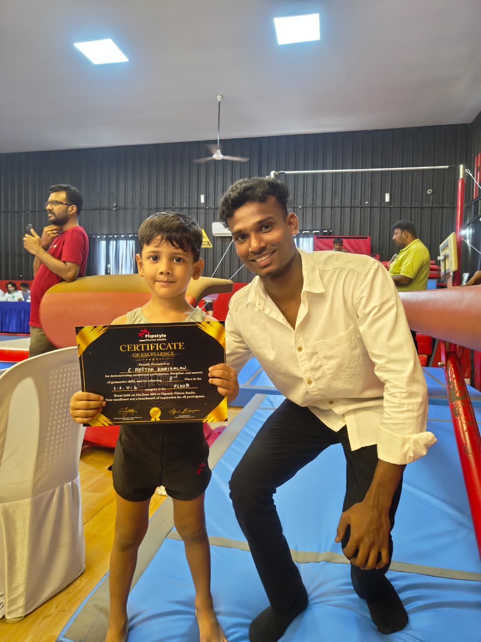 Aditya holding his Flipstyle Fitness Studio certificate of excellence for gymnastics